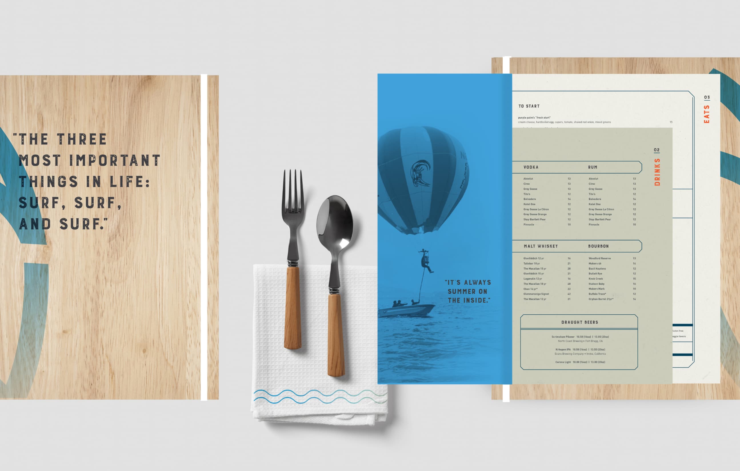 A wall art piece with the quote 'THE THREE MOST IMPORTANT THINGS IN LIFE: SURF, SURF, AND SURF.' next to a wooden table with cutlery on a napkin, embodying a surfing lifestyle theme. There is also a menu from Jack O'Neill Restaurant & Lounge with various meal options, styled in a minimalistic design with a vintage balloon featuring the brand logo in the background.
