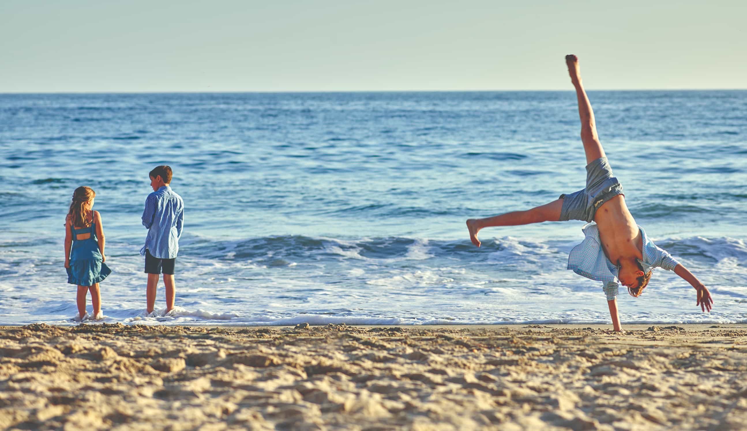 A couple sit outside while overlooking the beach 
