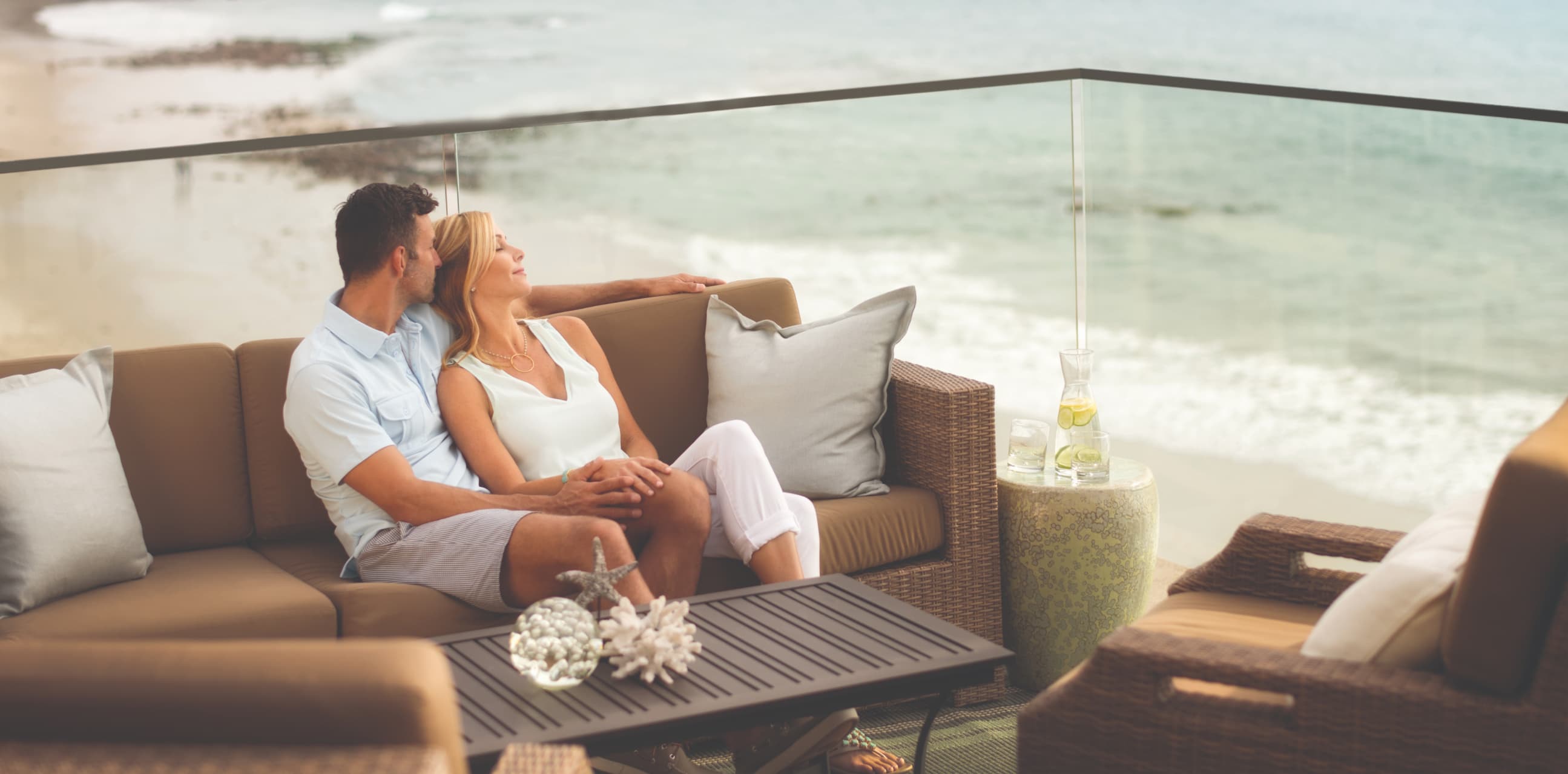 A couple sit outside while overlooking the beach 